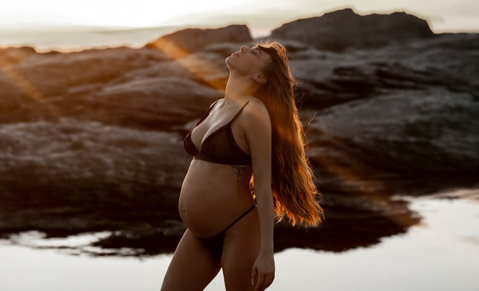 Panoramic maternity portrait held in golden coastal light