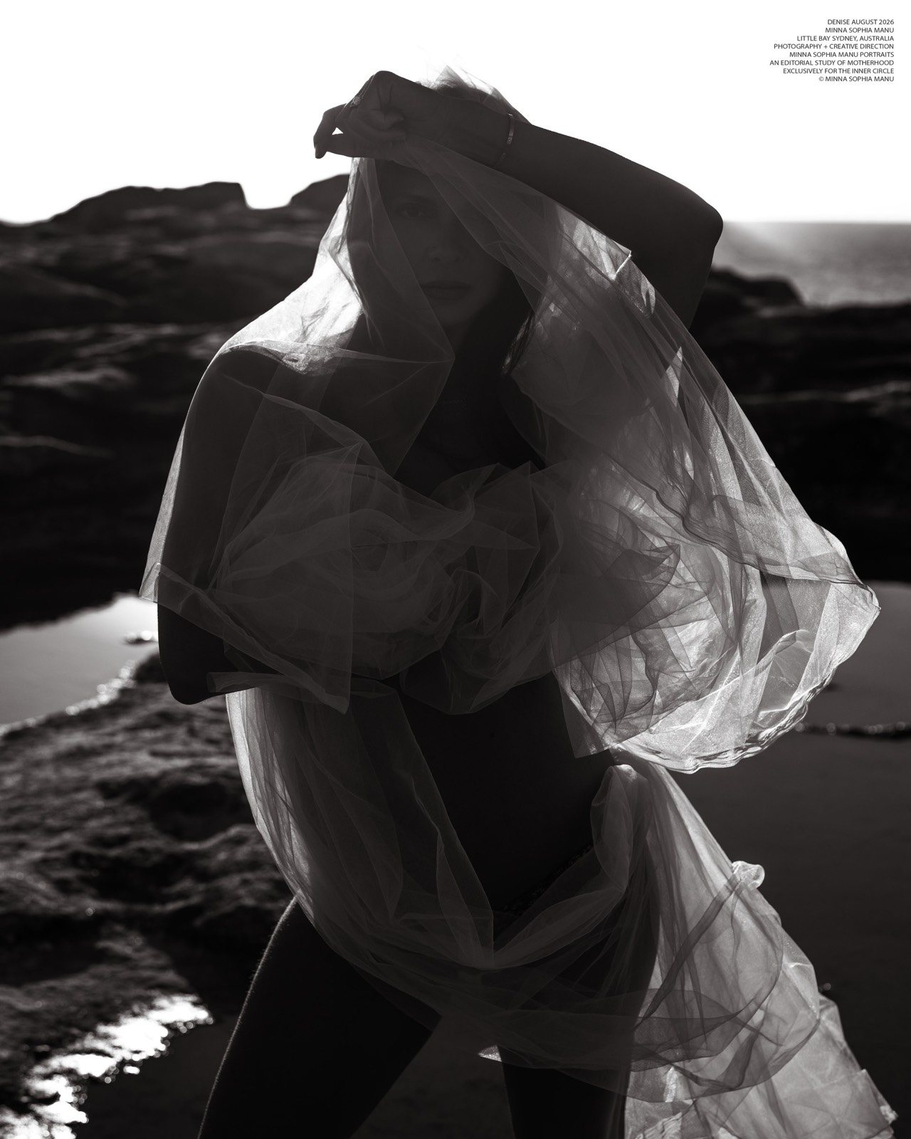 Veiled black and white maternity portrait on coastal rocks